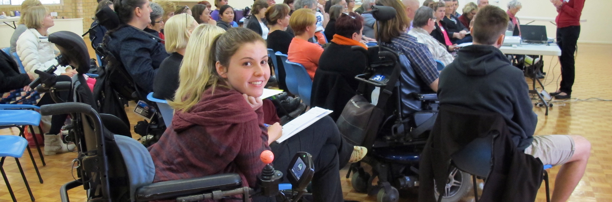 Smiling young lady in a wheelchair at an event