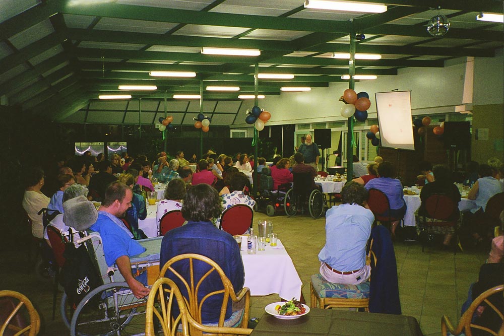 People, some in wheelchairs, gathered in a hall for a cru event