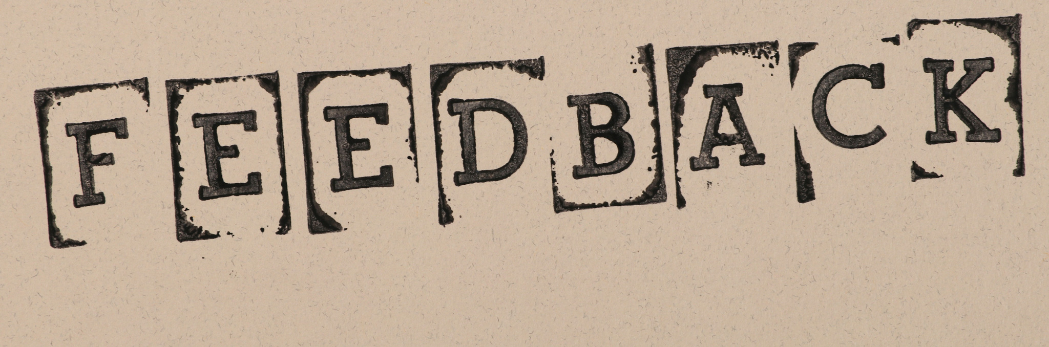 Black letters in typewriter font saying FEEDBACK on brown paper