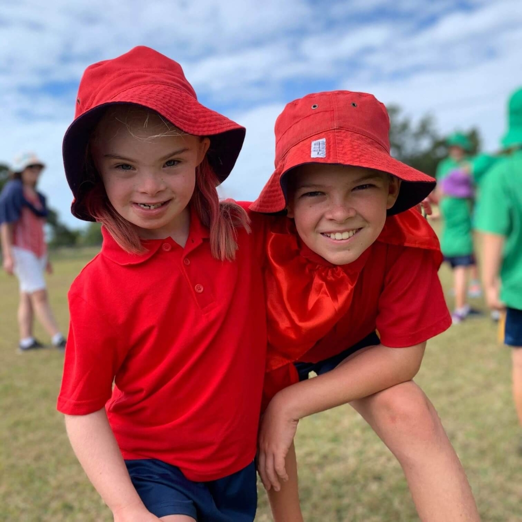 Two children wearing school sports uniform on school oval