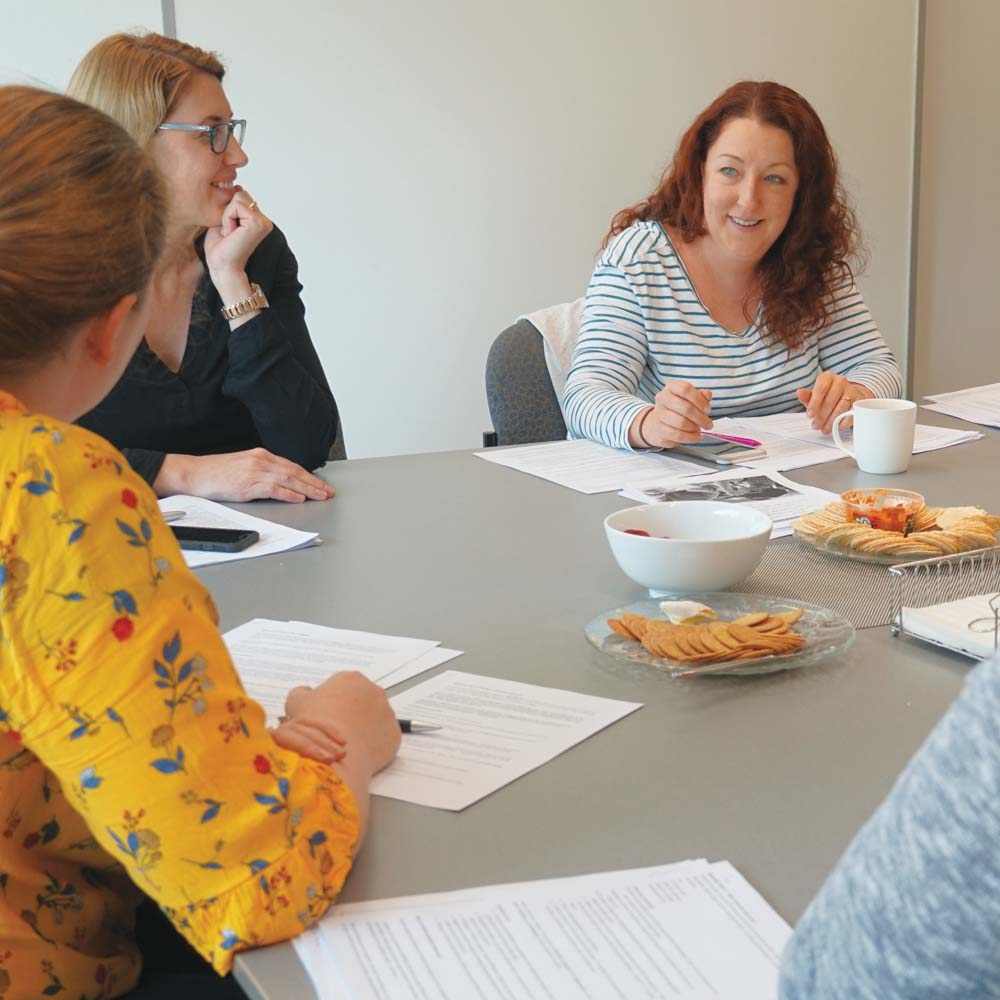 Three women in a meeting sitting at a table