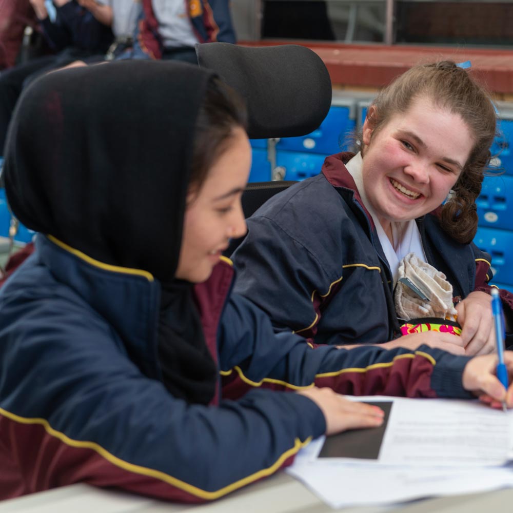 Two girls in school jumpers laughing