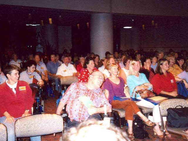 A large group of people enjoying themselves at a conference, including many people with disability