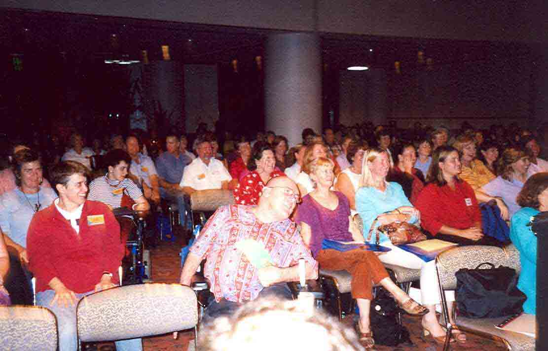 A large group of people enjoying themselves at a conference, including many people with disability