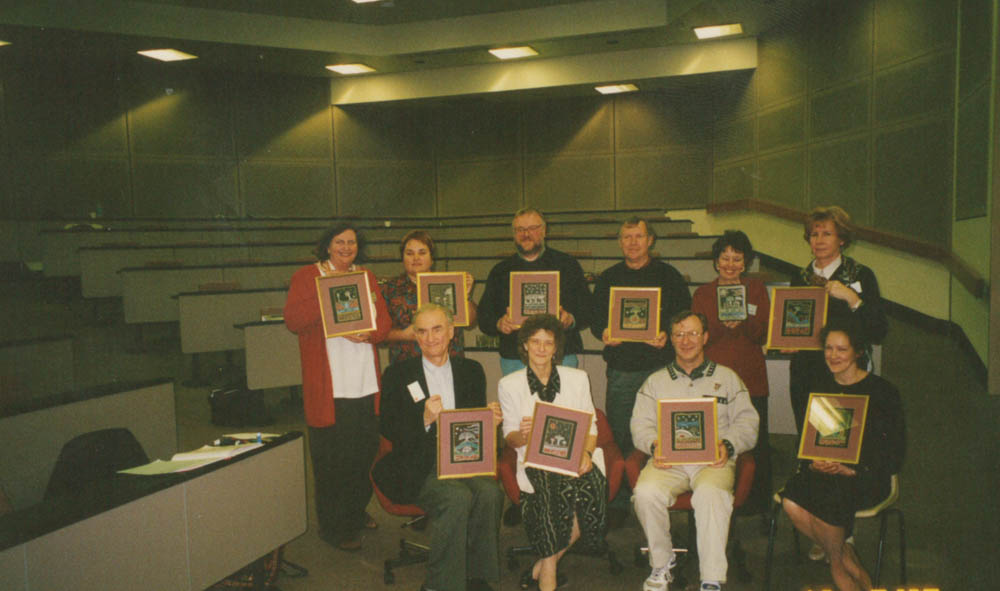 A group of people all holding images in frames