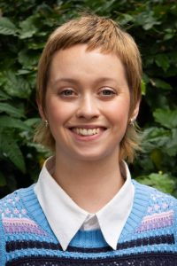 Jess with short blond hair and a happy smile