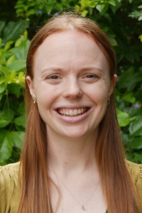 Nellie with long red hair smiling.