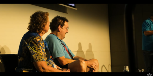 Jenni and Rohan Pidgeon seated on stage alongside one another